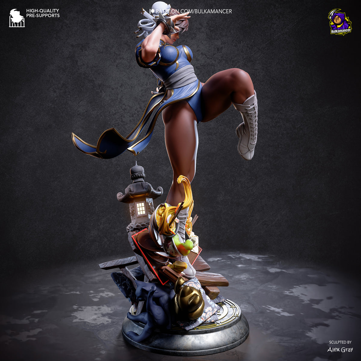 A detailed collectible statue of Chun-Li in a dynamic kicking pose, mounted on a decorative base with a lantern and rocks. The figure wears a blue and white outfit with gray boots and headpiece.