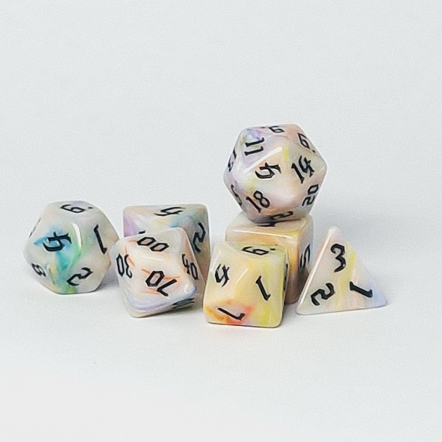 Set of colorful polyhedral dice on a light gray background