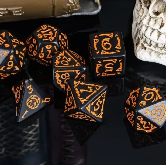 Black dice with orange numbering on a dark surface