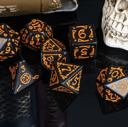 Black dice with orange numbering on a dark surface
